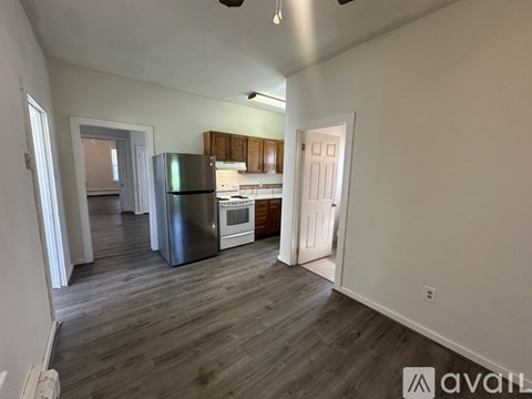 A kitchen with a refrigerator, oven, and sink is visible.