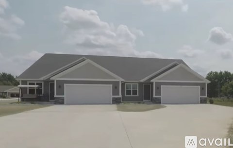 A modern house with a grey roof and two garages.