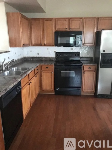 A kitchen with wooden cabinets and a black stove top oven.