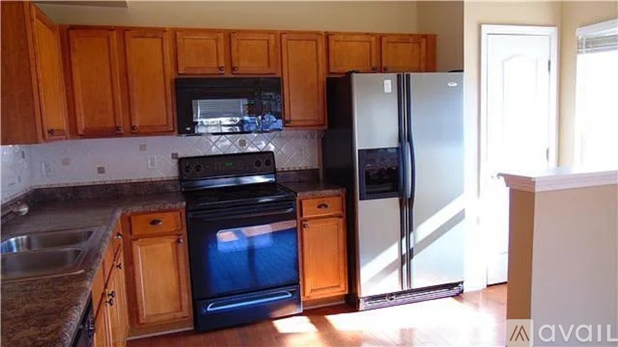 A kitchen with wooden cabinets and a black oven.