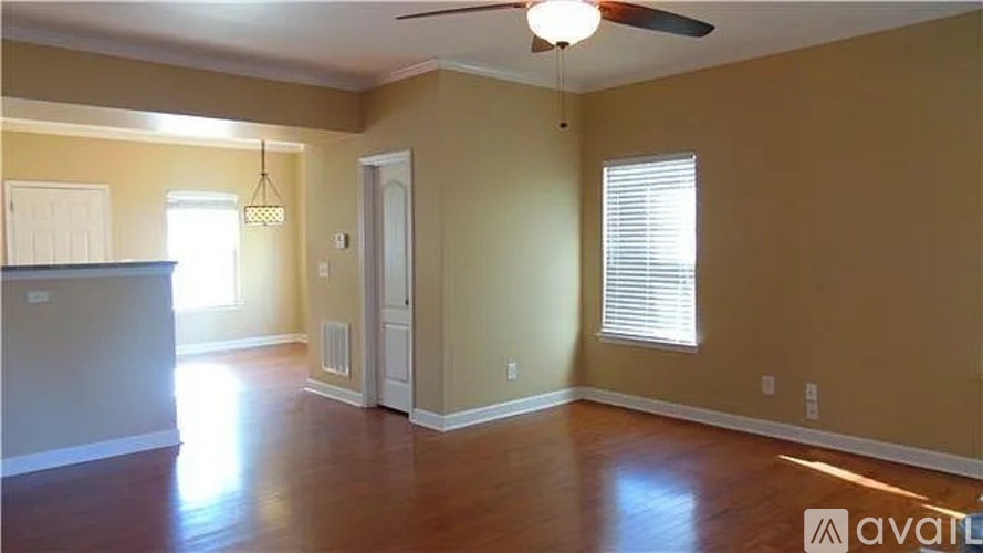 A room with a ceiling fan and wooden flooring.