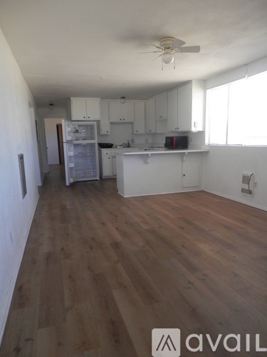 A kitchen with white cabinets and a refrigerator.