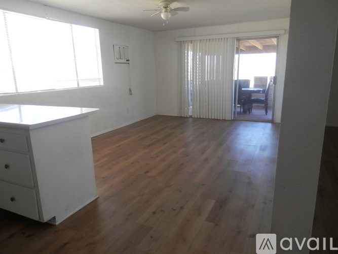 A room with wooden floors and a ceiling fan.