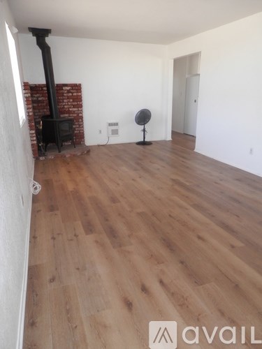 A room with a wood burning stove and a fan.