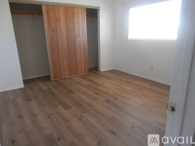 A room with a wooden floor and a wooden door.