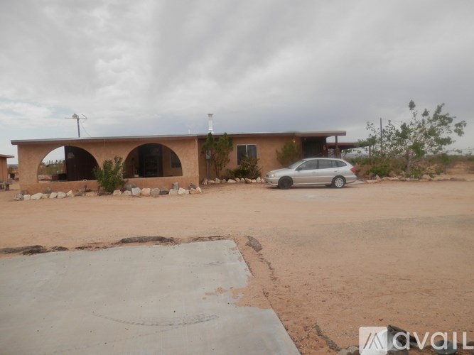 A car is parked in front of a house with a driveway.