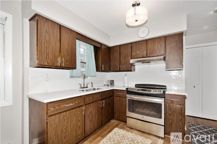 A kitchen with wooden cabinets and a stainless steel oven.