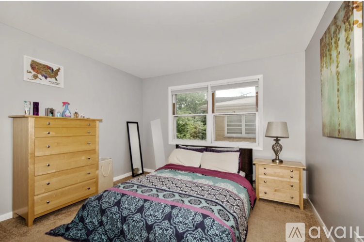 A bedroom with a bed, dresser, and window.