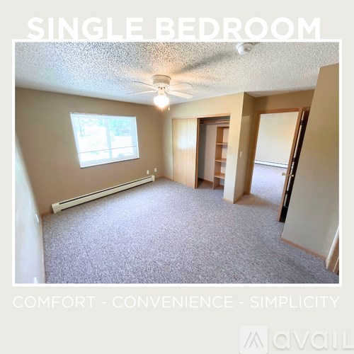 A single bedroom with carpeted floor and a window.