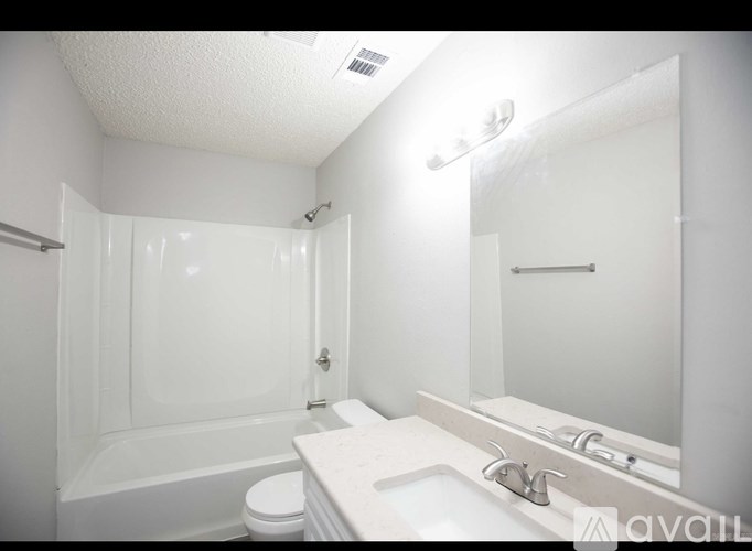 A white bathroom with a toilet, sink, and bathtub.