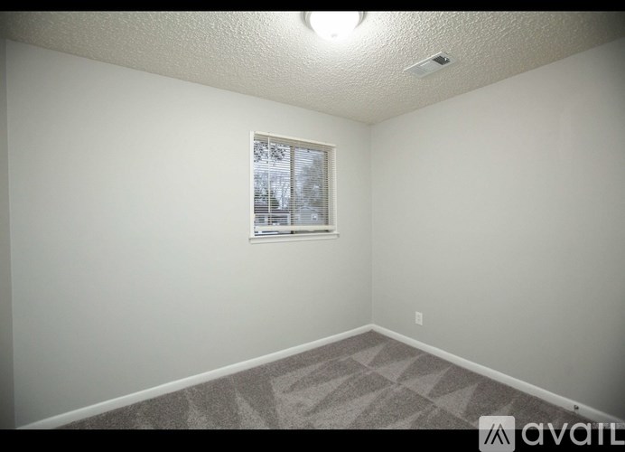 A room with a window and carpeted floor.