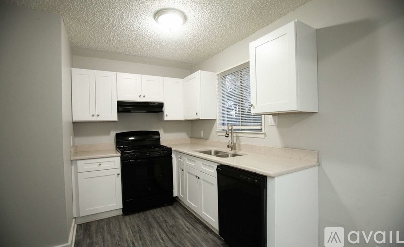 A kitchen with black appliances and white cabinets.