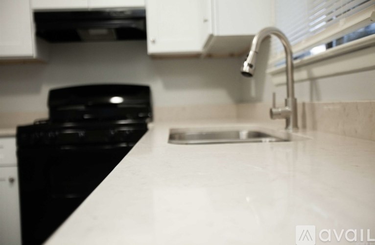 A black dishwasher is in a kitchen with a white counter.