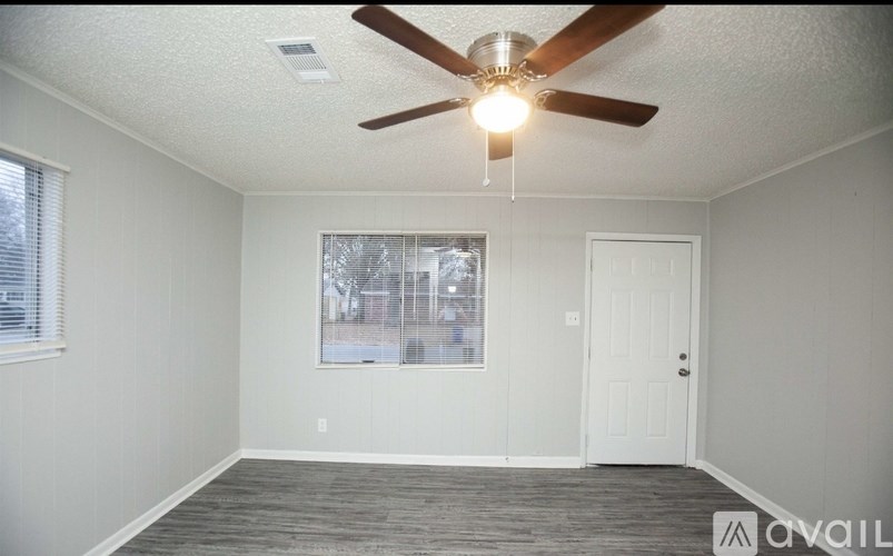 A room with a ceiling fan and a window.