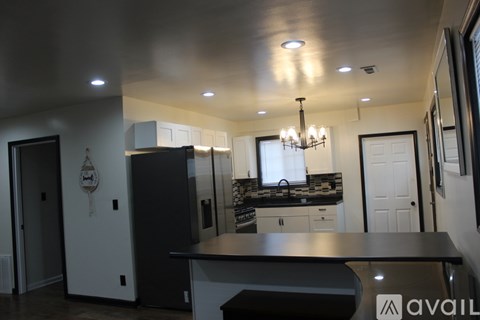 A kitchen with a black countertop and white cabinets.