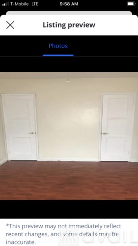 A room with two white doors and wooden flooring.