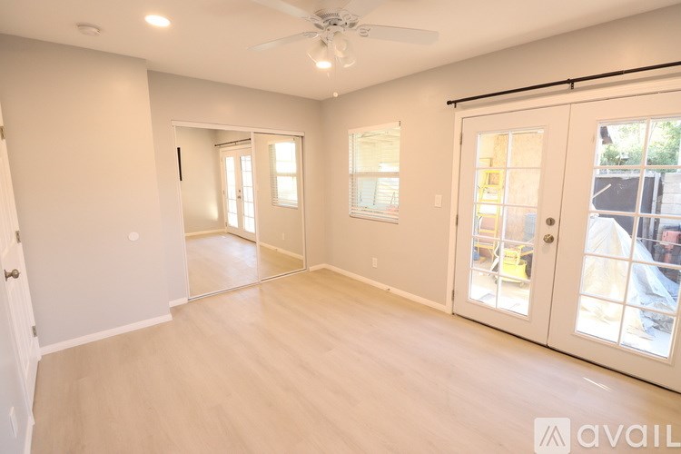 A spacious room with a ceiling fan and sliding glass doors.