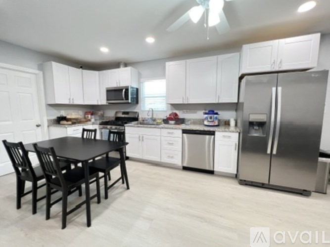 A kitchen with white cabinets and a black table.