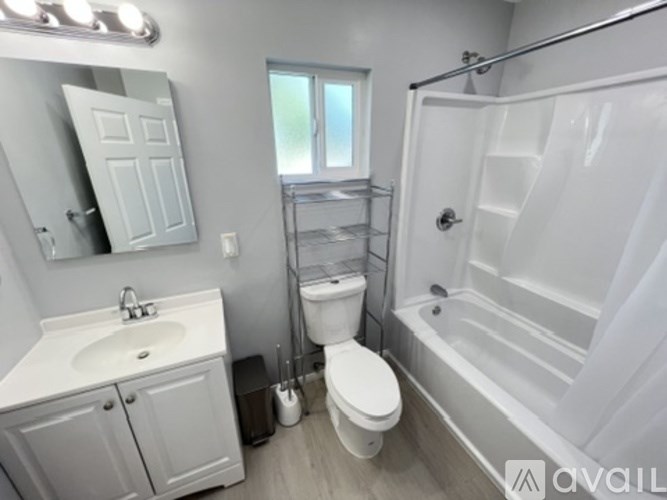 A white bathroom with a sink, toilet, and bathtub.