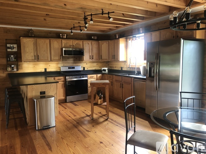 A kitchen with wooden floors and stainless steel appliances.