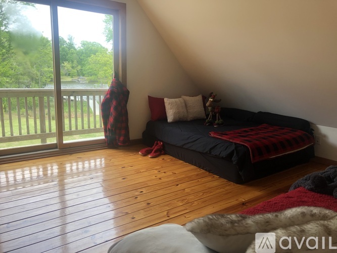 A bedroom with a large bed and a view of a deck outside.