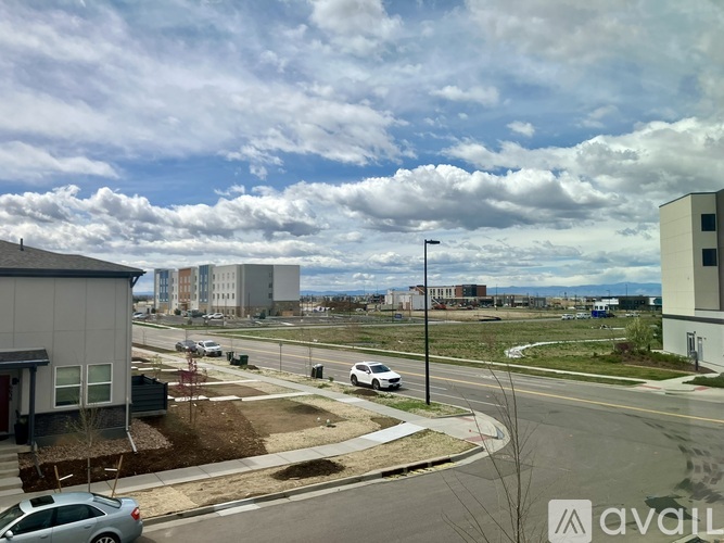 A street view of a residential area with cars and buildings.