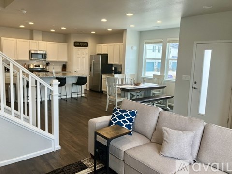 A living room with a couch and a kitchen area in the background.