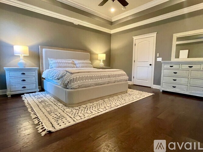 A bedroom with a large bed, a dresser, and a mirror.