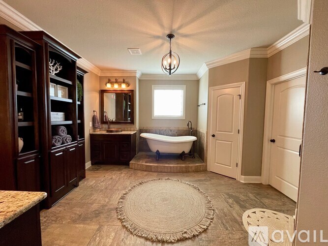 A bathroom with a tub and a rug on the floor.