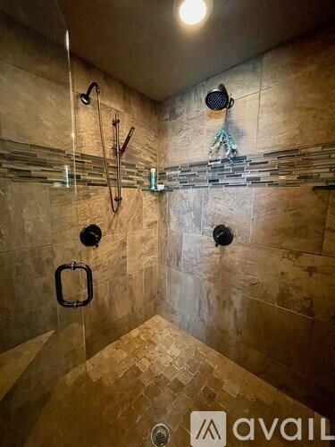 A shower with a glass door and a glass wall.