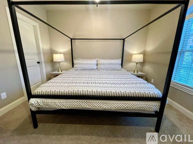 A bed with a black frame and a striped bedspread is in the image.