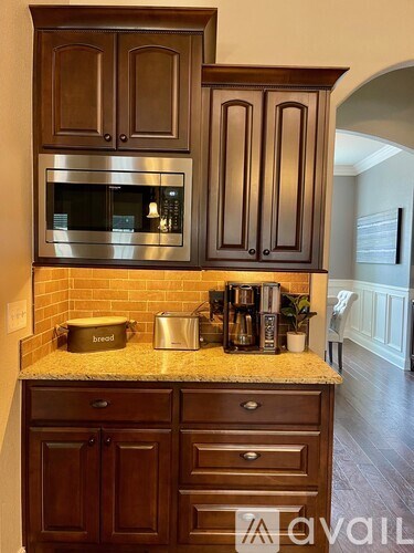 A kitchen with brown cabinets and a granite countertop.