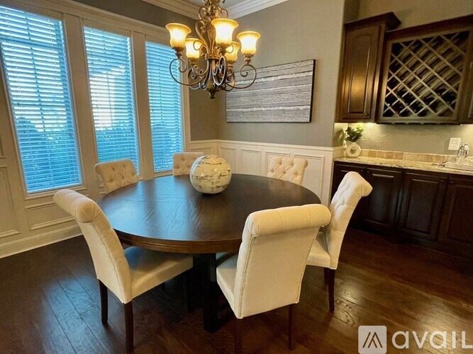 A dining room with a round table and chairs.