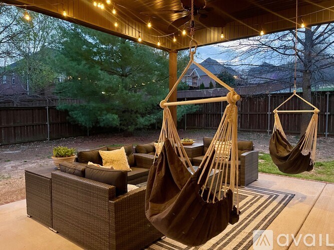 A hammock is suspended between two wooden poles in a backyard.