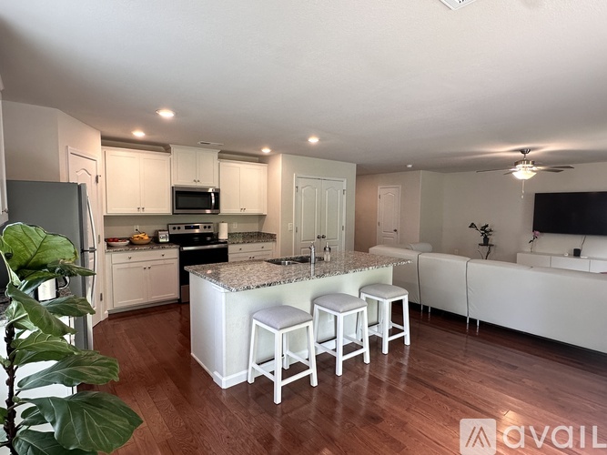 A kitchen with white cabinets and a granite countertop.