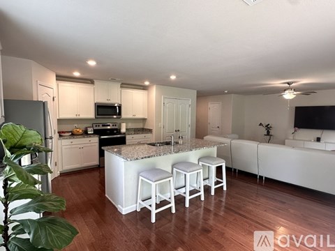 A kitchen with white cabinets and a granite countertop.