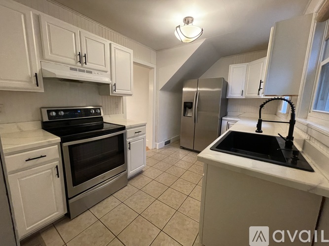 A kitchen with white cabinets and appliances.