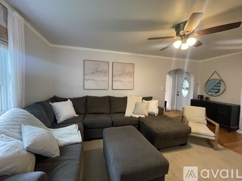 A living room with a grey sofa and a white chair.