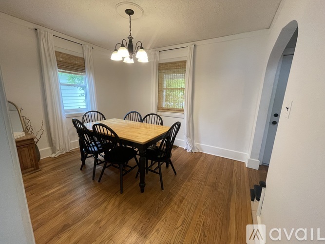 A dining room with a wooden table and chairs.