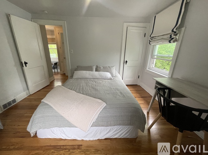 A bedroom with two beds and a desk.
