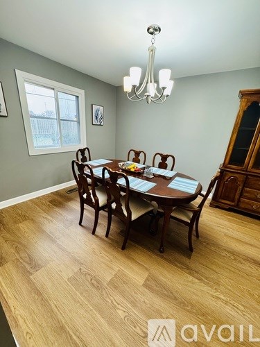 A dining room with a wooden table and chairs.