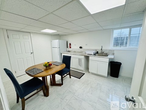 A kitchen with a table and chairs.