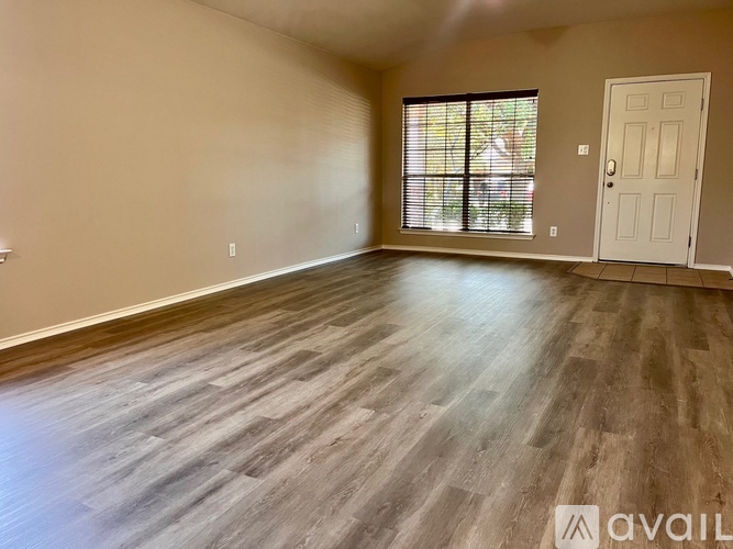 A room with wooden flooring and a white door.