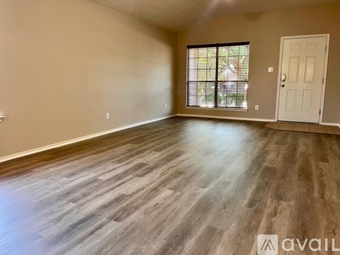 A room with wooden flooring and a white door.