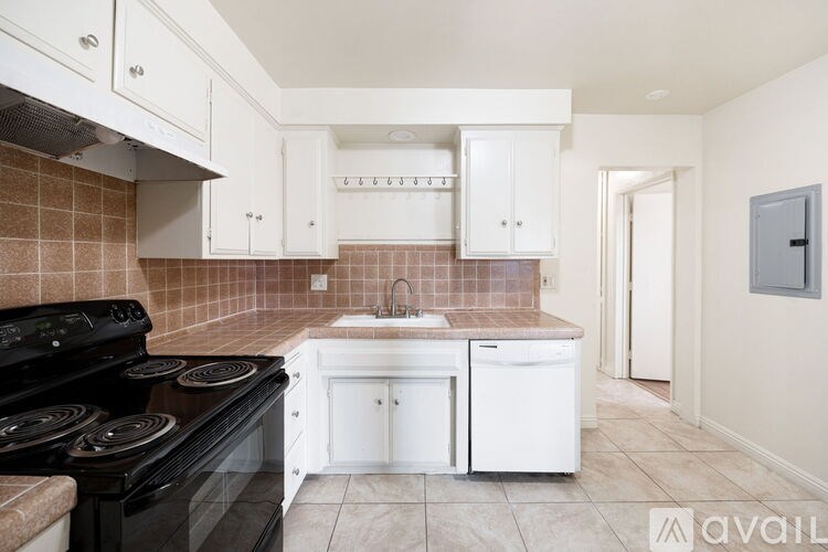 A kitchen with white cabinets and a black stove top oven.