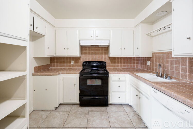 A kitchen with white cabinets and a black oven.