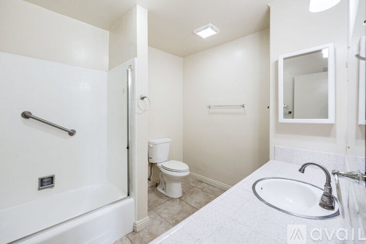 A white bathroom with a toilet, sink, and bathtub.