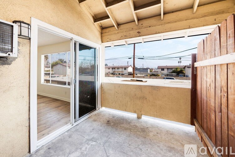 A patio area with a sliding glass door and a wooden fence.