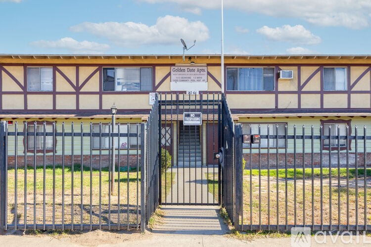 A gated entrance to a building with a sign that reads "Golden Date Apartments".