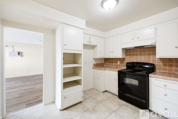 A kitchen with white cabinets and a black stove top oven.